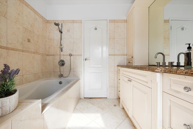 bathroom featuring vanity, tile walls, tile patterned floors, and tiled shower / bath