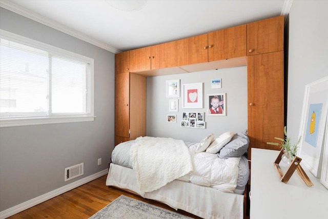 bedroom with wood-type flooring and crown molding