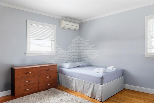 bedroom featuring crown molding, light hardwood / wood-style floors, and a wall unit AC