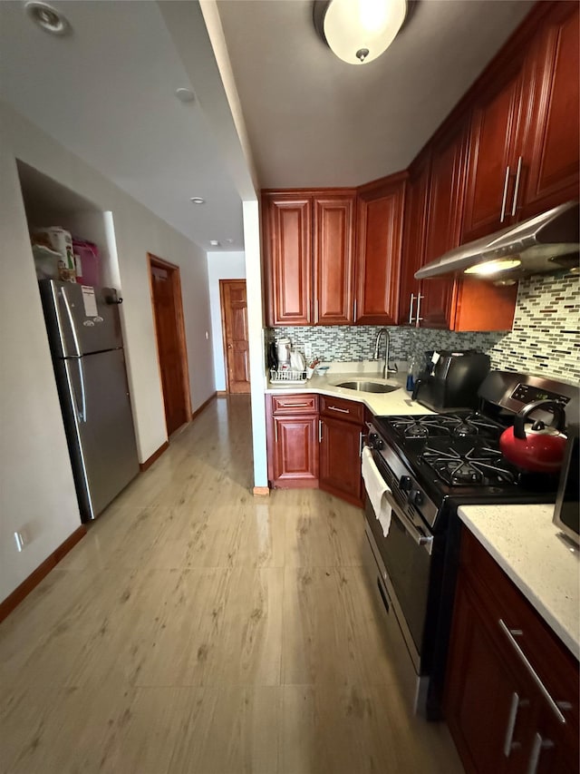 kitchen featuring appliances with stainless steel finishes, sink, backsplash, and light hardwood / wood-style floors