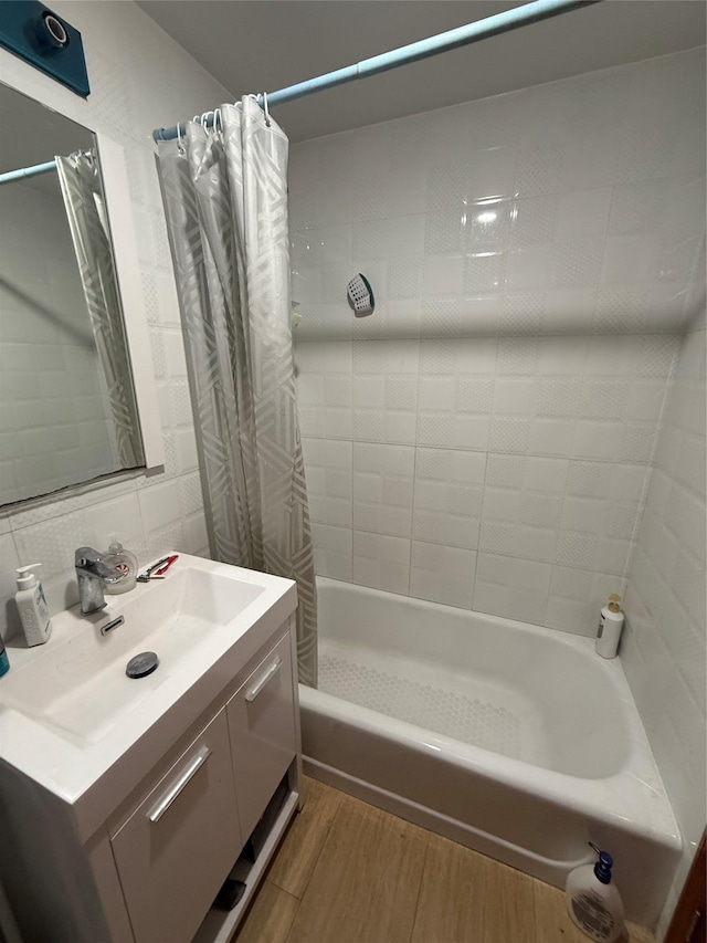 bathroom featuring tile walls, vanity, shower / bathtub combination with curtain, hardwood / wood-style flooring, and decorative backsplash