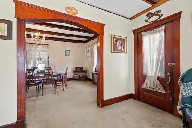 carpeted dining room featuring beamed ceiling and a notable chandelier