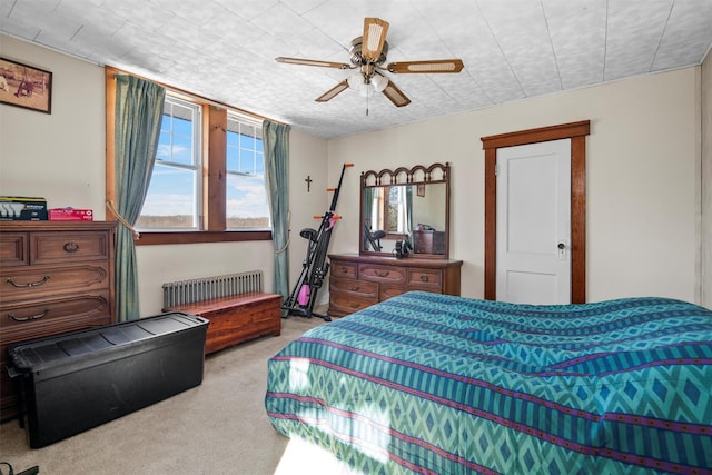 carpeted bedroom featuring radiator heating unit and ceiling fan