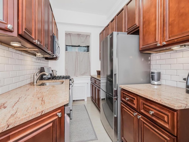 kitchen featuring light stone counters, decorative backsplash, and stainless steel appliances