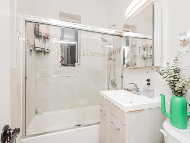 full bathroom with vanity, combined bath / shower with glass door, and toilet