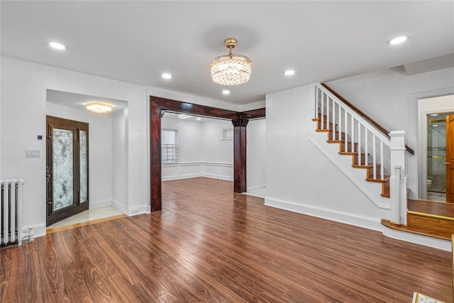 foyer with hardwood / wood-style flooring, radiator, a wealth of natural light, and a chandelier