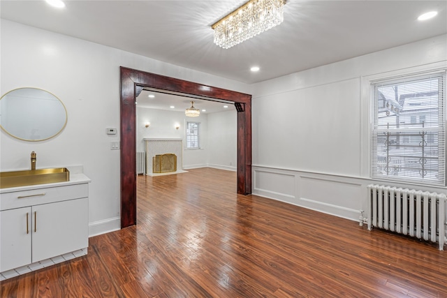 interior space featuring radiator, a notable chandelier, and dark hardwood / wood-style floors