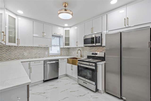 kitchen with sink, backsplash, stainless steel appliances, and white cabinets