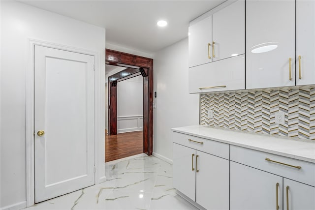 kitchen featuring white cabinetry and backsplash