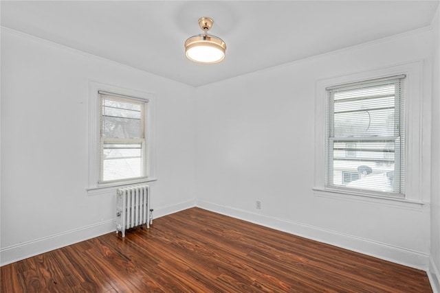 empty room featuring dark hardwood / wood-style flooring and radiator heating unit