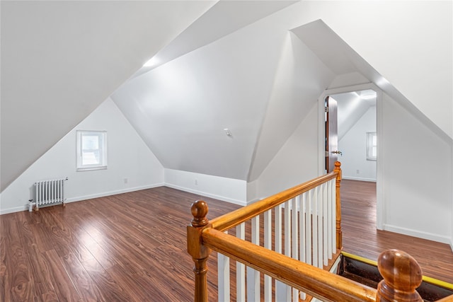 bonus room with radiator, vaulted ceiling, and dark hardwood / wood-style floors