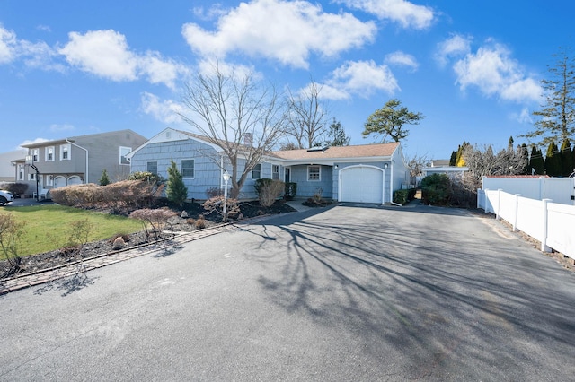 ranch-style house featuring a garage and a front yard