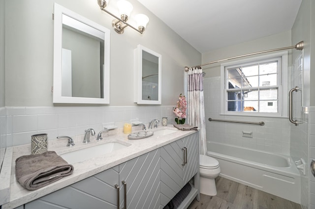 full bathroom featuring shower / tub combo with curtain, toilet, tile walls, vanity, and hardwood / wood-style flooring