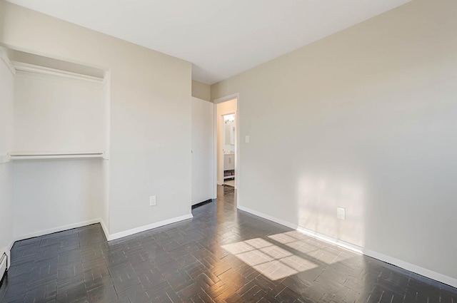 unfurnished bedroom featuring a baseboard radiator and a closet