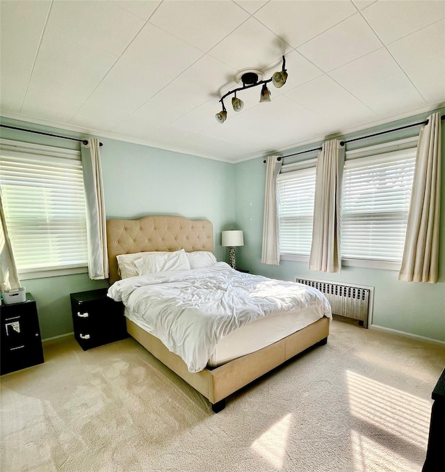 carpeted bedroom with radiator and baseboards