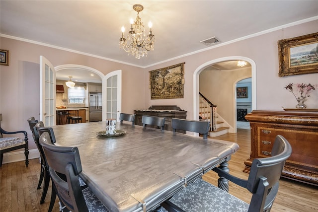 dining area featuring ornamental molding, hardwood / wood-style floors, and a notable chandelier