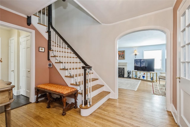 interior space with light wood-type flooring and crown molding