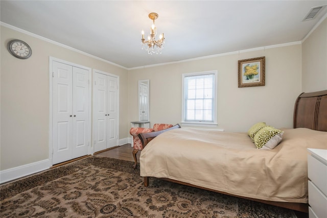 bedroom with multiple closets, crown molding, wood-type flooring, and an inviting chandelier