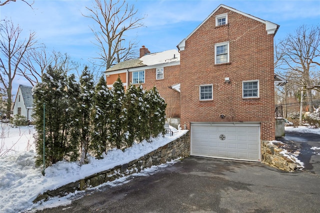 snow covered property featuring a garage