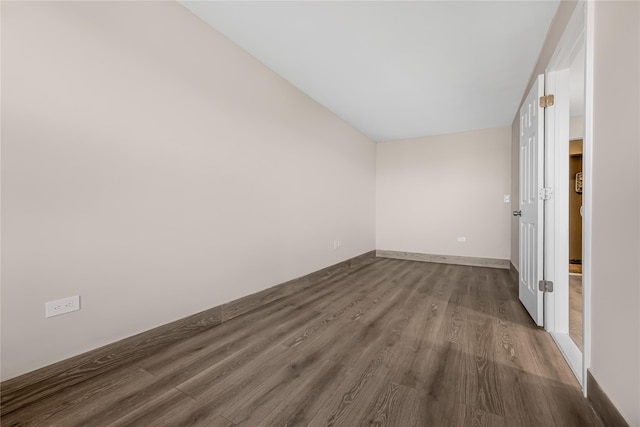 unfurnished room with dark wood-style floors and baseboards