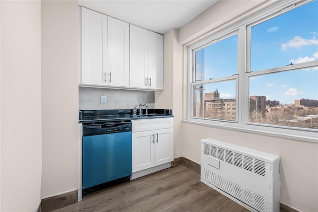 kitchen featuring white cabinetry, dishwashing machine, radiator heating unit, and wood finished floors