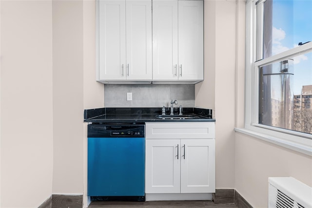 kitchen featuring dishwashing machine, baseboards, a sink, white cabinetry, and dark countertops