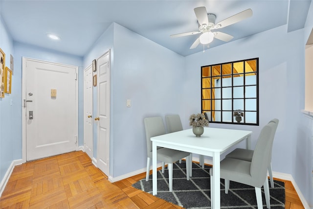 dining room with ceiling fan and light parquet floors