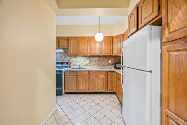 kitchen featuring sink, decorative light fixtures, light tile patterned floors, white refrigerator, and stove