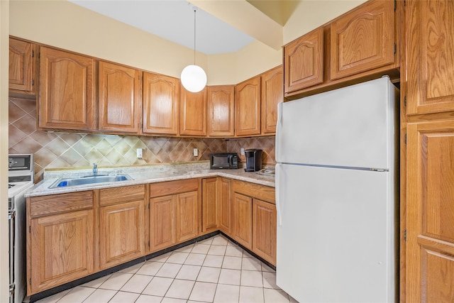 kitchen featuring white fridge, sink, decorative backsplash, and decorative light fixtures