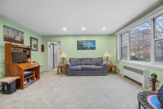 living room featuring light colored carpet and radiator heating unit