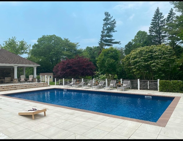 outdoor pool with a patio area and an outdoor structure