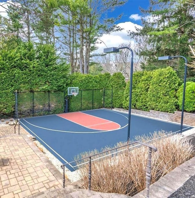 view of basketball court with fence and basketball court