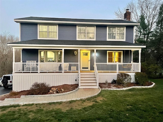 view of front of home with a front yard and a porch