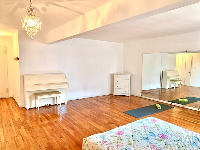 bedroom with hardwood / wood-style floors and a notable chandelier