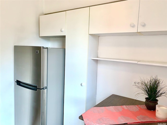 kitchen with white cabinets and stainless steel fridge