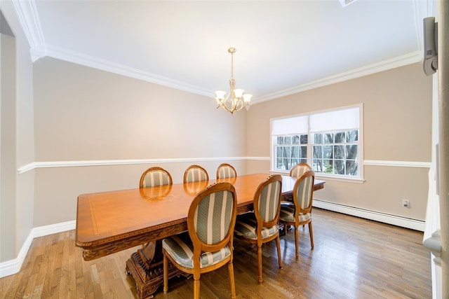 dining room with a baseboard heating unit, crown molding, and light hardwood / wood-style floors