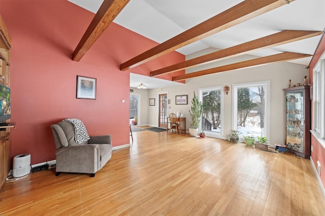 unfurnished room featuring lofted ceiling with beams and light hardwood / wood-style flooring