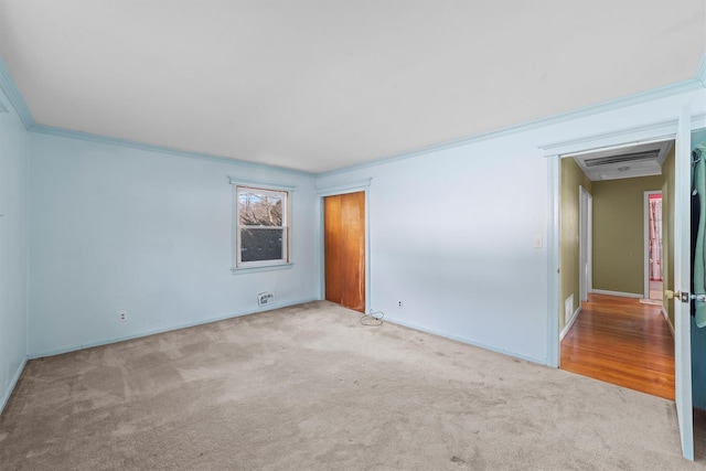 empty room with light carpet and crown molding