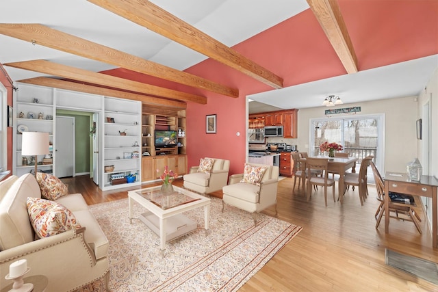 living room with light hardwood / wood-style flooring and beamed ceiling