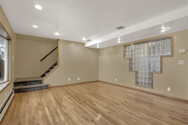 basement with a baseboard radiator and light wood-type flooring