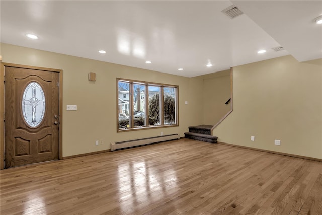 foyer with a wealth of natural light, light hardwood / wood-style floors, and a baseboard heating unit