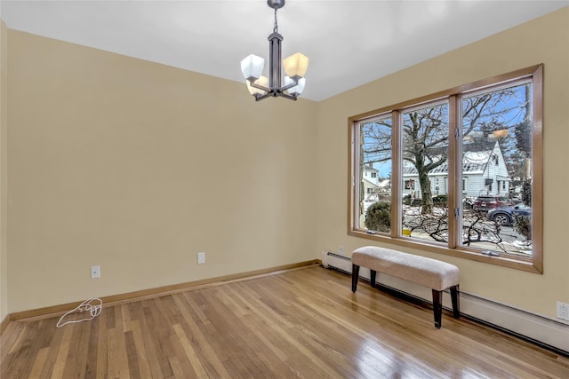 interior space featuring baseboard heating, a chandelier, and light hardwood / wood-style flooring