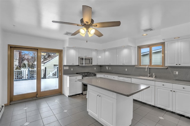 kitchen featuring sink, a center island, baseboard heating, stainless steel appliances, and white cabinets