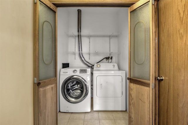 laundry area with independent washer and dryer and light tile patterned flooring