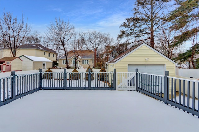 snow covered deck with a garage and an outdoor structure