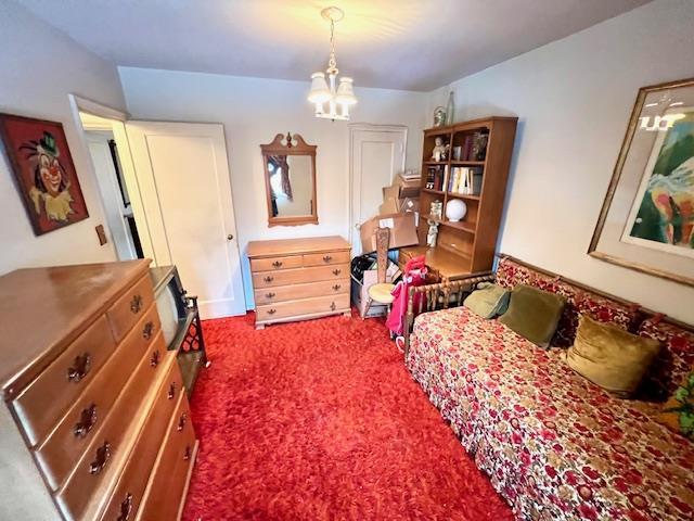 carpeted bedroom with a chandelier