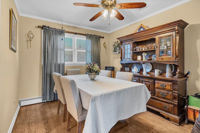 dining space featuring a baseboard heating unit, plenty of natural light, wood finished floors, and ornamental molding