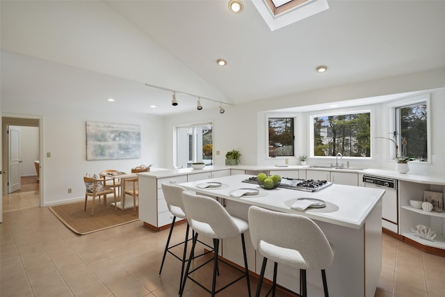 kitchen featuring white cabinets, white dishwasher, light countertops, and a peninsula