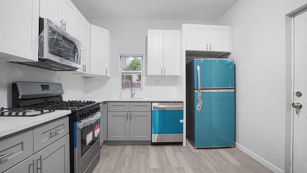 kitchen featuring appliances with stainless steel finishes, gray cabinetry, light wood-type flooring, sink, and white cabinetry