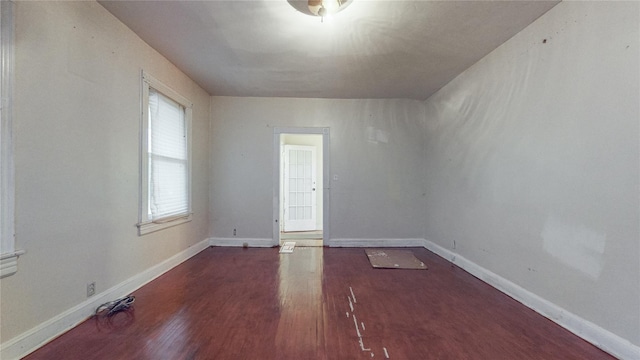 empty room featuring dark wood-style floors and baseboards